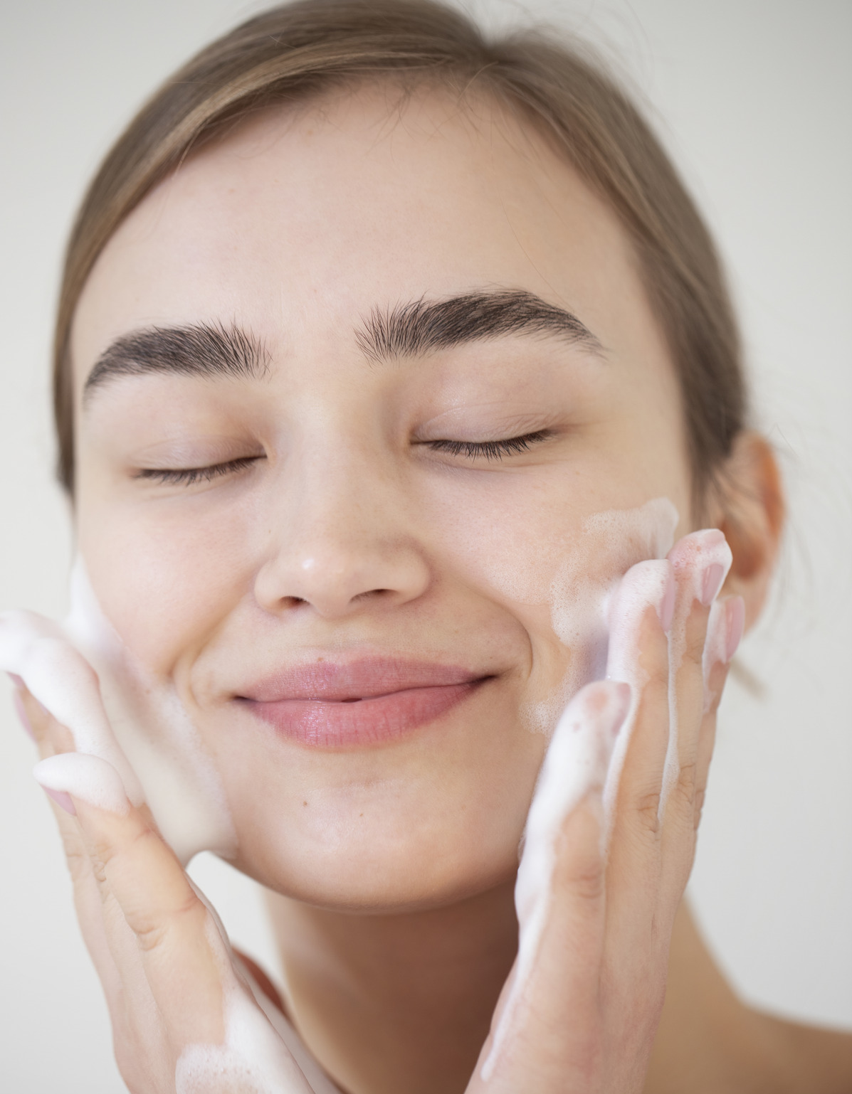 portrait-beautiful-woman-with-clear-skin-washing-face-with-foam-cleanser